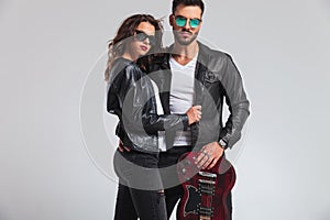 Fashion rock and roll couple standing with electric guitar