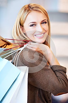 Fashion, sale and shopping woman or customer is happy and excited holding bags at a store. Discount, offer and deal for