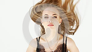 Fashion sensual alluring blond woman in black dress looking at camera over white background