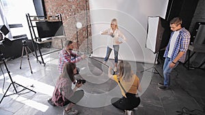 Fashion session, group of young creative people learn studio shooting during photography workshop on background of