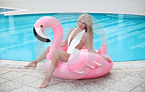 Fashion blond model woman in white bikini posing on Pink in