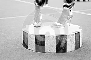 Fashion shoes on column outdoor. Legs in glamour golden shoes paris, france. High heel shoes on female feet on city