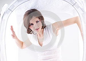 Fashion shoot of a young woman in a light cube