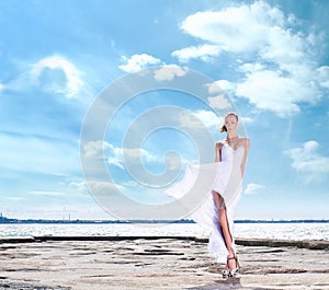 Fashion shoot of a young woman on a sea background