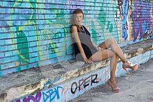 Model in a summer dress next to a graffiti wall