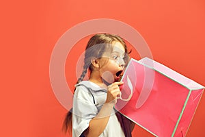 Fashion and shopaholism concept. Girl holds pink shopping bag photo