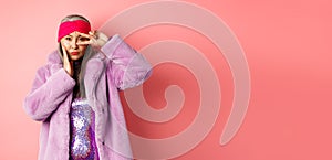 Fashion and shopping. Beautiful asian senior woman in stylish faux fur coat and headband, making peace sign on face and