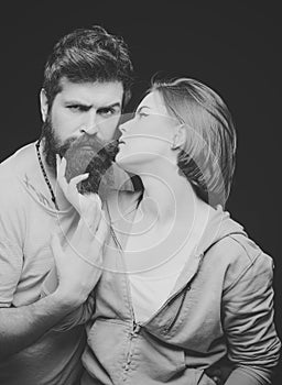 Fashion shot of couple after haircut. Barbershop concept. Woman on mysterious face with bearded man, black background