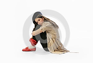 Fashion shot. Portrait of beautiful young girl, teen in retro style clothes posing at white studio background. Concept