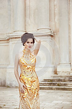 Fashion shot of stunning elegant woman in luxurious golden dress