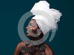 Fashion is a silent language. Studio shot of an attractive young woman posing in traditional African attire against a