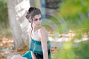 Fashion slim woman wearing green strapless short dress sitting sidewalk