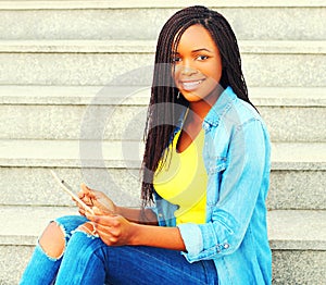 Fashion smiling african woman using tablet pc computer