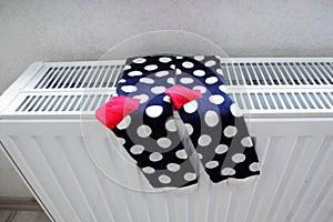 Fashion socks drying on heating radiator