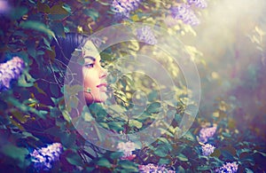 Fashion spring model girl portrait in lilac fantasy garden