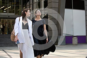 Fashion store. Happy smiling girlfriends women walking on street. Fashion blogger.