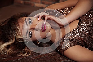 Fashion studio photo of beautiful young afro american woman with professional make-up wearing luxurious sequin dress