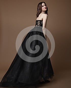 Fashion studio photo of elgant woman in long black dress