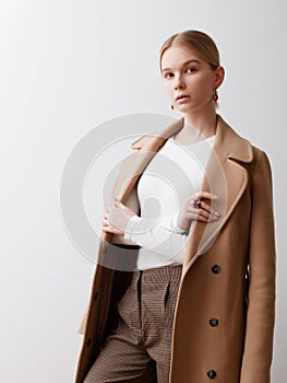 Fashion studio photo of young beautiful lady in beige coat on white background. Total beige. Fashion look book