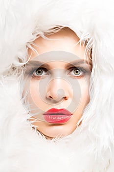 Fashion studio portrait of a beautiful fair-skinned woman in white fur closeup. Winter beauty in luxury. Beauty woman in luxury fu