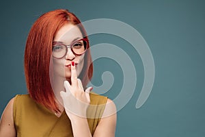 Fashion studio portrait of pretty young hipster red hair woman with bright make up and glasses , wearing stylish