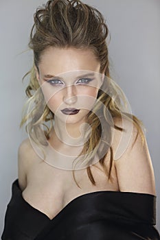 Fashion studio potrait of beautiful young blond woman with dark makeup