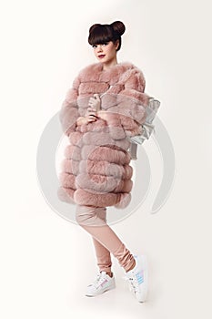 Fashion studio teen look style in pink fur coat advertise backpack and shoes. Fashionable student girl wears leather