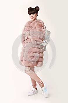 Fashion studio teen look style in pink fur coat advertise backpack and shoes. Fashionable student girl wears leather