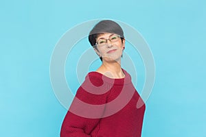 Fashion, style and people concept - smiling pretty middle-aged woman on turquoise background