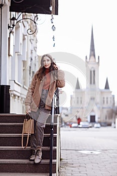 Fashion style portrait. beautiful stylish girl with long hair walks in the city. Portrait of attractive girl on the street. Spring