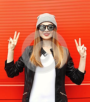 Fashion stylish cool girl having fun wearing a rock black leather jacket and sunglasses with hat