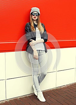 Fashion stylish pretty woman wearing a rock black leather jacket and sunglasses with hat