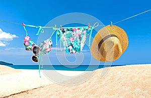 Fashion summer swimsuit bikini, sunglasses and big hat on rope. Summer bikini and accessories stylish outfit beach set. Ocean sea