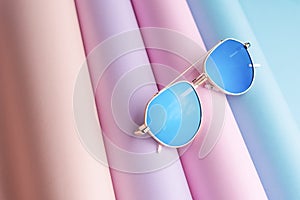 Fashion of Sunglasses with blue lens put on colorful paper background