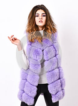 Fashion trend concept. Winter fashionable wardrobe for female. Boutique selling fur. Woman makeup face wear fur vest