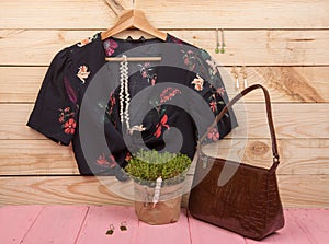 Fashion trends - black crop top / blouse in floral print on hangs on hanger, bag and jewelry: hair pearl clip, necklace, earrings