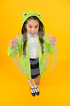 Fashion trends in case of rain. Happy child got idea with fashion look on yellow background. Small girl with long hair