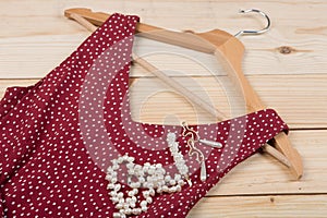 Fashion trends - red dress in polka dots on hanger and pearl jewelry: necklace, hair pearl clip, earrings