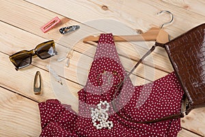 Fashion trends - sunglasses, bag, red dress in polka dots on hanger and jewelry: pearl necklace, hair pearl clip, earrings