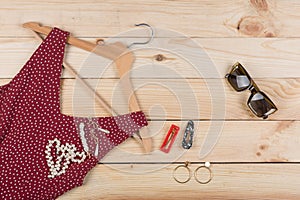 Fashion trends - sunglasses, red dress in polka dots on hanger and jewelry: pearl necklace, hair pearl clip, earrings