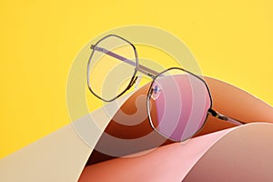 fashion trendy eyes glasses for correcting vision on a creative background, wave from paper, colorful background