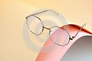 Fashion trendy eyes glasses for correcting vision on a creative background, wave from paper, colorful background