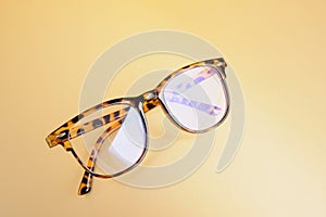 Fashion trendy eyes glasses for correcting vision on a creative background, wave from paper, colorful background