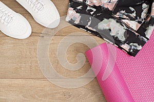 Fashion trendy trainers and leggings, pink yoga mat. Hipster Set. Female sneakers, sport shoes in flat lay style, top view. Fitnes