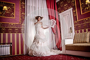 Fashion vogue photo beautiful bride with curly hair in a gorgeous wedding dress with precious perfect poses in amazing interior