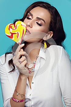 Fashion. Woman With Beauty Face Makeup Holding Candy.