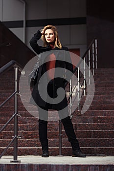Fashion woman in black coat walking on night city street