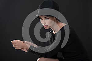 Fashion woman. Black and white portrait of beautiful young elegant lady in black dress and hat. Vintage styling