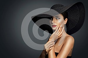 Fashion Woman in Black Wide brim Hat with Red Lips Makeup side view. Elegant Lady Portrait looking away over Gray. Beautiful Model