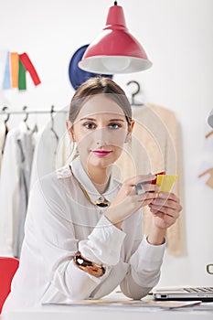 Fashion woman blogger in a creative workspace choosing colors.